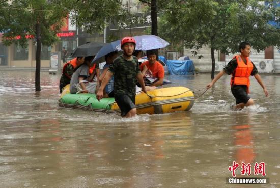 7月19日，河北邯郸消防官兵正在对市民展开救援。中新社发 刘学维 摄