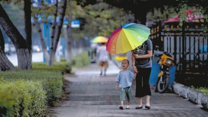 昨日下午3点左右，长春上空开始下起小雨。南湖大路上一位母亲刚刚接到幼儿园放学的孩子 新文化记者 郭亮 摄