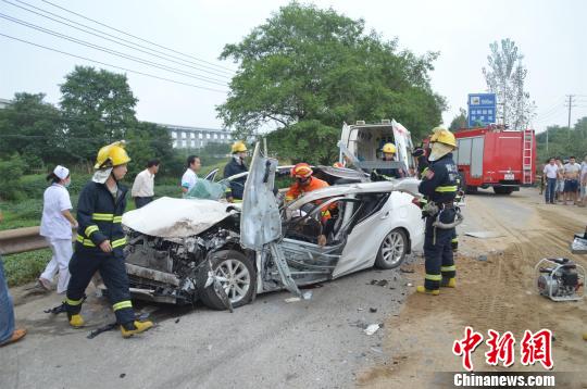 小轿车面目全非，消防官兵展开救援。 詹枭 摄