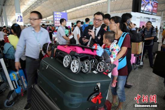 8月2日，热带风暴“妮妲”袭港，天文台发出八号热带气旋警告信号，机场多班机受风暴影响，需要取消或延误，大批旅客滞留。当天中午台风过后，机管局重新编配航班，预计可处理500班来往香港的航班。中新社记者 洪少葵 摄