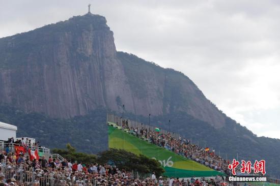 资料图：在里约观看赛艇比赛的观众，在赛场后面是里约地标耶稣山。 中新网记者 盛佳鹏 摄