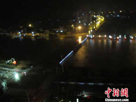 图为17日夜晚，从海南省临高县穿城而过的文澜江的江水不断上涨，洪水翻腾。 付美斌 摄