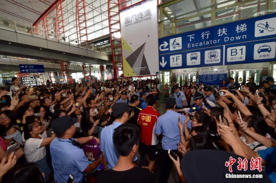 8月20日，包揽里约奥运4枚金牌的中国乒乓球队抵达首都机场，受到球迷的热情追捧。图为刘国梁、马龙、张继科、刘诗雯等出现在首都机场，被大批媒体和球迷包围。中新网记者 金硕 摄
