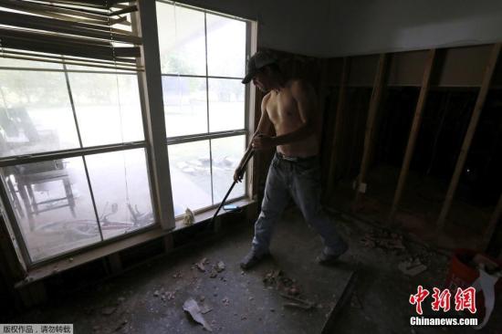 当地时间2016年8月22日，美国路易斯安那州登罕斯普陵，居民进行清理工作。截至目前，洪灾已导致13人死亡、上万人无家可归、至少4万户家庭受到不同程度损失。一些受灾民众已开始自发清理房屋，开始重建家园。