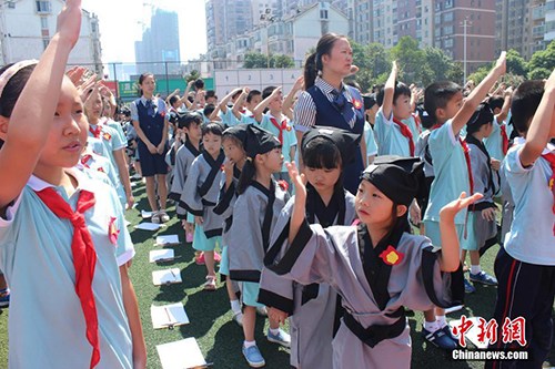 8月29日，长沙市岳麓区一小学举行开学典礼，一年级新生们身着汉服，在老师的带领和高年级同学的帮助下完成了“开笔礼”。校方希望以此方式教育学生从小要立志、做好人，学会感恩老师，勇于表达。刘着之 摄