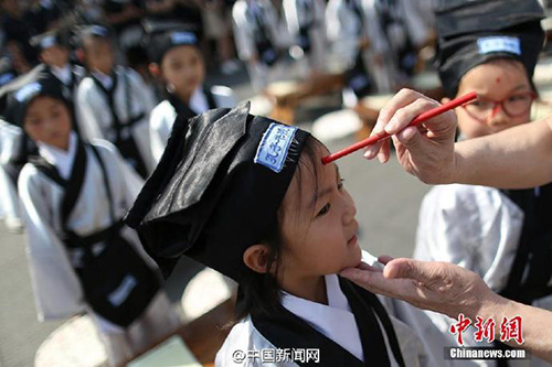 8月31日百余小学新生在南京夫子庙大成殿前“开笔破蒙”,通过向孔子像行礼、诵读《论语》、学写“人”字、朱砂开智、聆听师长寄语等,宣告正式成为一名学生。