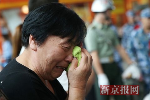 一位女士看着正在列队、即将登上火车的孙子,落了泪。