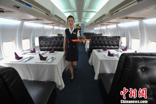 9月9日，中国内地首家由真飞机改造而成的餐厅在武汉光谷德意风情步行街正式开业，餐厅服务人员按空乘标准进行选拔，并统一着装。 张畅 摄