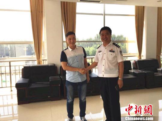 衡水市政府副市长、公安局长程蔚青（右）和视频拍摄者尹某（左）合影。图为衡水市公安部门提供