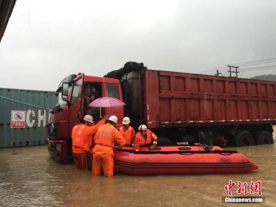 图为福州市马尾区亭江消防中队消防官兵用橡皮艇，携带绳索等救援器材涉水徒步进入救援现场。由于屋内积水较深，人员已爬到了附近一辆大货车上等待救援，随后，消防官兵成功救出5名被困群众，并送往安全地带...