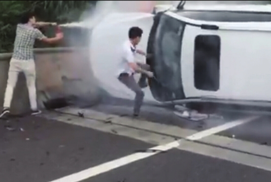 9月12日下午，厦蓉高速郴州龙潭路段，一名小伙子用灭火器 给车头灭火，另一人则用尽全力踹车辆的前窗。视频截图