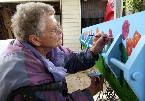 一名老人正在为自己的棺材绘制图案。