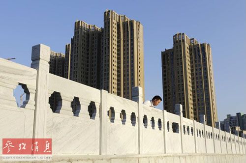 一名房产中介业务员站在北京一个新建小区旁(美国《华尔街日报》网站)