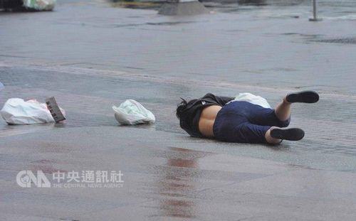 中度台风“鲇鱼”侵袭台湾，9月27日上午台北市已出现间歇的风雨，路上民众被强风吹倒在地。台湾“中央社”记者王飞华摄