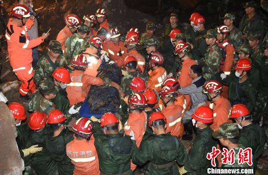 图为：当地消防将遇难者遗体抬出受灾现场。 初士浩 摄