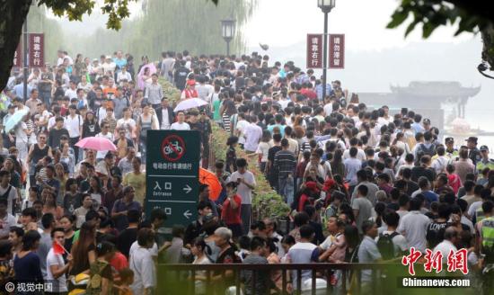 10月1日，国庆长假首日，杭州西湖断桥景区人潮涌动。吴煌 摄 图片来源：CFP视觉中国