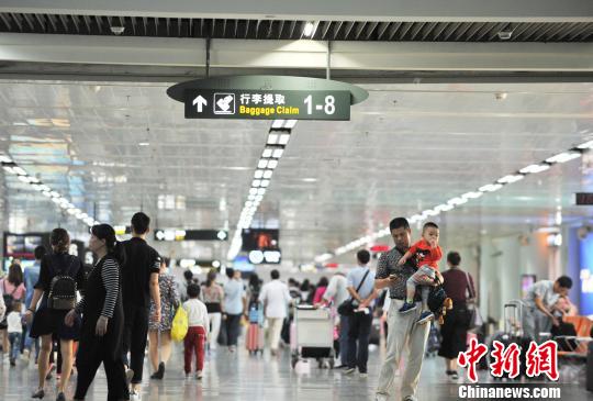 资料图：图为海口美兰机场到达大厅迎来大量进港旅客。　楚洪雨 摄