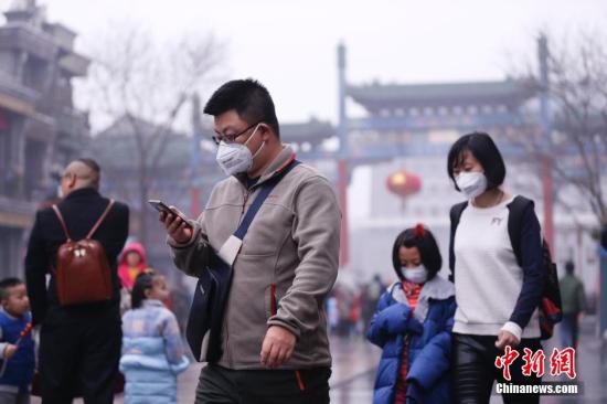 2016年2月11日，北京开启“阴雨模式”，气温有所下降，回暖旋律戛然而止。同时，受不利扩散条件影响，局地空气质量再度降至重度污染水平。图为在北京前门大街游玩的市民。 中新社记者 杜洋 摄