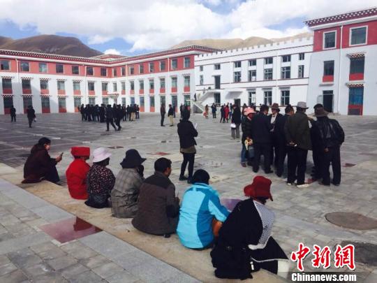 图为地震发生后，杂多县政府工作人员站在办公楼外躲避余震 尕玛求加 摄