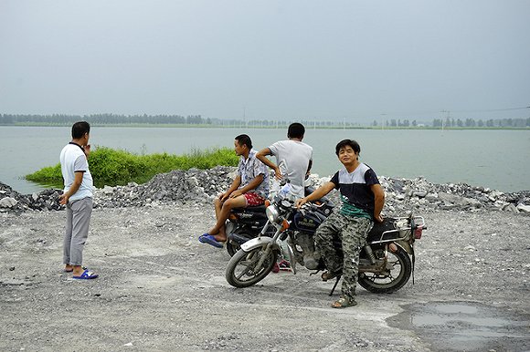 大李庄家村的沉陷湖边，几个村民在湖边聊天。摄影：孙俊彬。