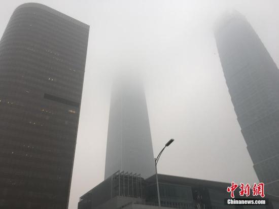10月19日消息，昨天16时，北京市气象台发布霾黄色预警信号，预计昨日傍晚至19日北京大部地区有中度霾，南部地区有重度霾。图为国贸附近被雾霾笼罩，能见度降低。富田 摄