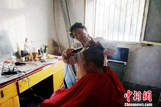 图为侯春云在为一位老人理发。 王秋兰 摄