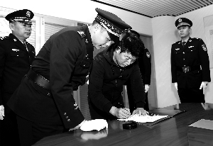 11月12日，在北京首都机场，闫永明在逮捕证上签字。新华社发