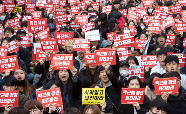 2016年11月12日，韩国民众在首尔市中心一带手举标语，要求朴槿惠下台。（新华社发）