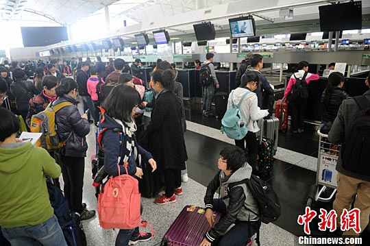 资料图:香港国际机场,旅客正在办理登机手续。<a target=\'_blank\' href=\'http://www.chinanews.com/\'>中新社</a>记者 谭达明 摄 资料图:香港国际机场,旅客办理登机手续。中新社记者 谭达明 摄