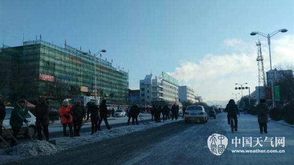 22日早晨,呼伦贝尔街头市民齐心协力清理路面积雪。(图/侯海婷)