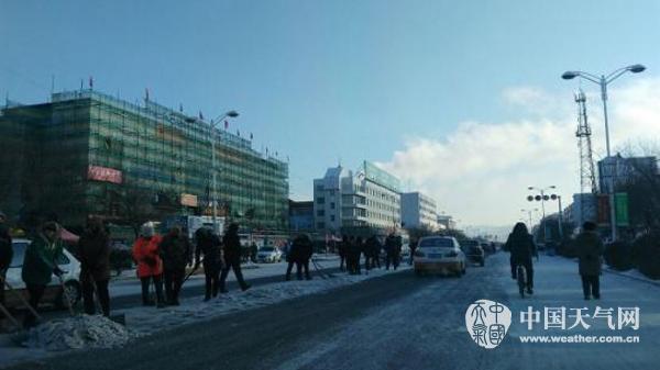 22日早晨，呼伦贝尔街头市民齐心协力清理路面积雪。（图/侯海婷）