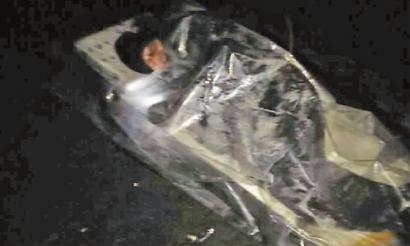 洞内男子躺在泡沫板上，身上还盖着塑料布