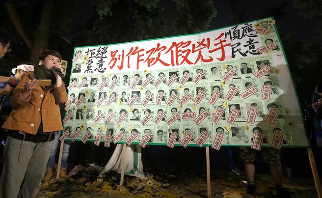 劳工在民进党“立委”肖像上贴上砍假凶手字条。（图片来源：台湾“中时电子报”）