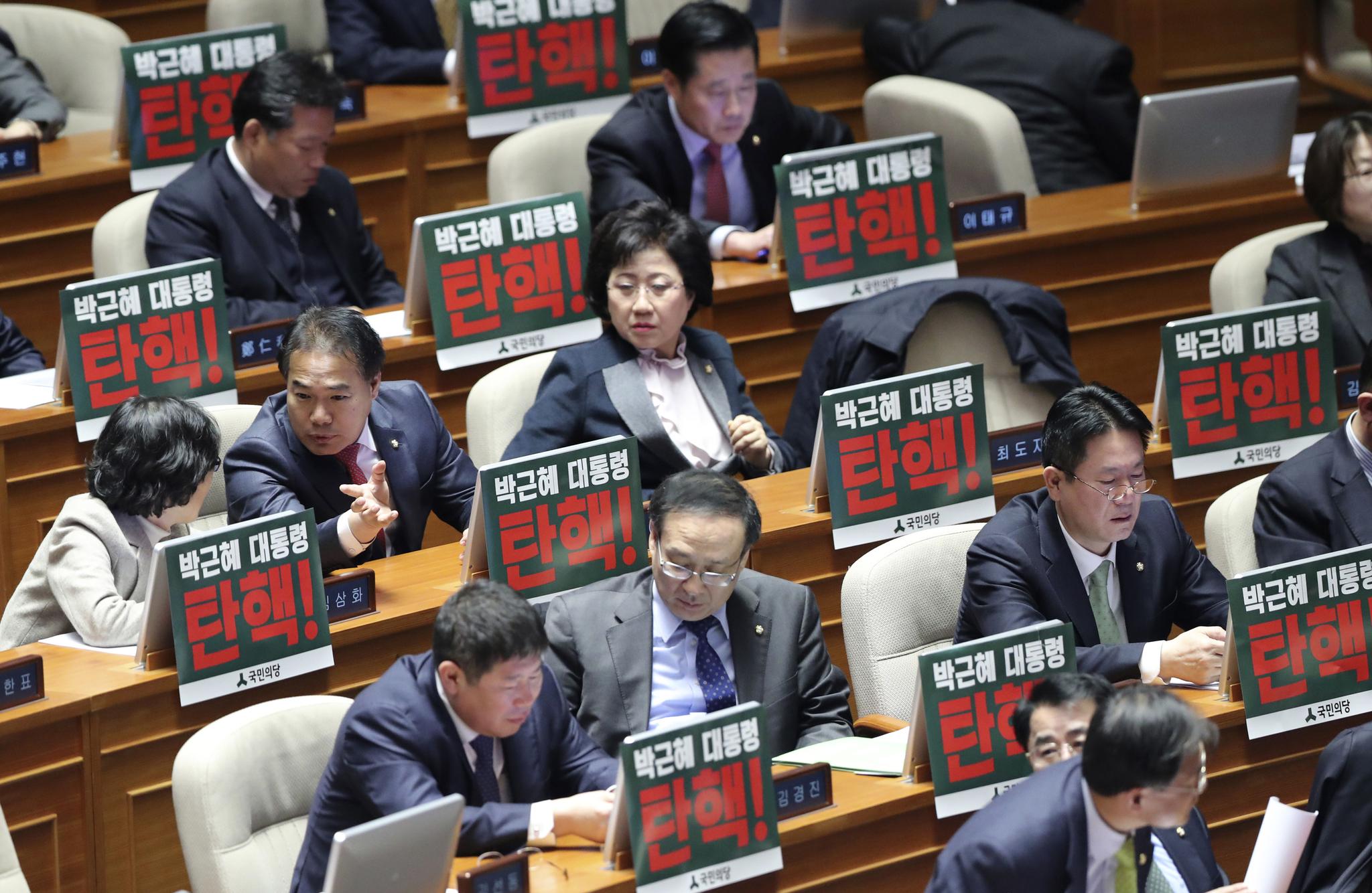 12月8日，韩国国会，在野党议员将写有“弹劾总统朴槿惠”的标语牌放在桌上。（新华/美联）
