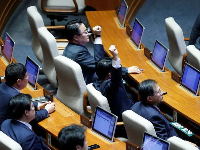 国会通过弹劾案后，议员举手庆祝。（新华/路透）