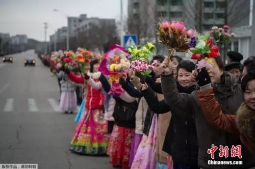 民众捧花夹道欢迎。