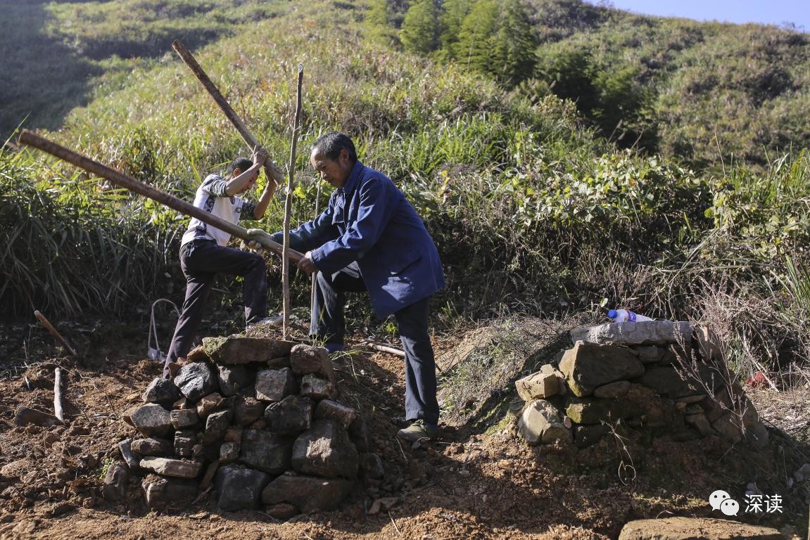 乐建作（左）和乐建九兄弟俩为刚刚去世的“老三”乐建卷修缮坟墓，旁边埋的则是老大岳建瑞