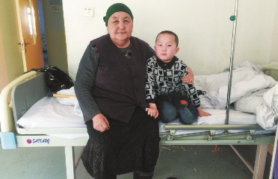 12月14日，阿依保力和奶奶依偎在病床上。