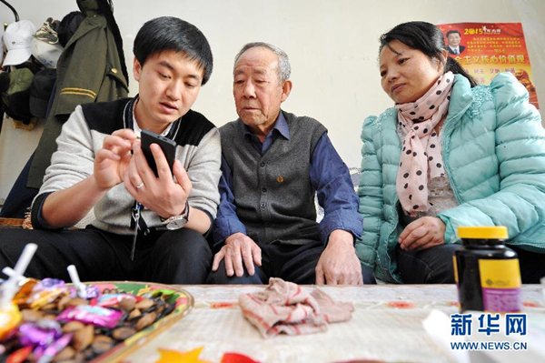 　　在宁夏回族自治区贺兰县马家寨社区，社区工作人员向老年人介绍如何使用智能居家养老呼叫手机。新华社记者彭昭之摄