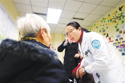 2016年12月20日，重庆家庭医生刘露霞（右）在社区医院向一位老年社区居民提供医疗服务。新华社记者唐奕摄
