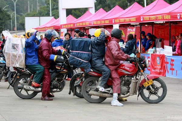 1月14日，中国广西梧州市。每年“春运”期间都有超过十万在广东工作的人员，驾驶摩托车途经梧州，赶回家过春节。为了保暖，他们在脚上裹上塑料袋。