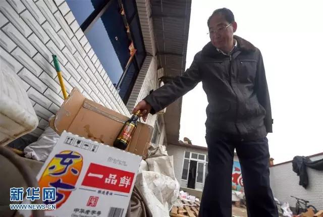 △执法人员展示非法调料加工窝点的假冒东古牌酱油。