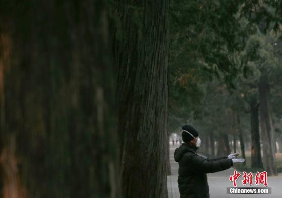 一位老人戴口罩在北京天坛公园健身(资料图)。中新社记者 刘关关 摄