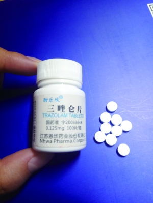 小图为记者收到的药品无外包装,白色小瓶子上写着“三唑仑片”,里面白色药片上却有VC字样。