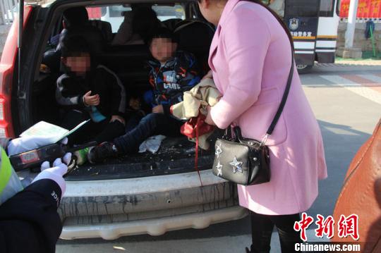在交警劝说下，家长将孩子从后备箱拉出来。　刘传海　摄