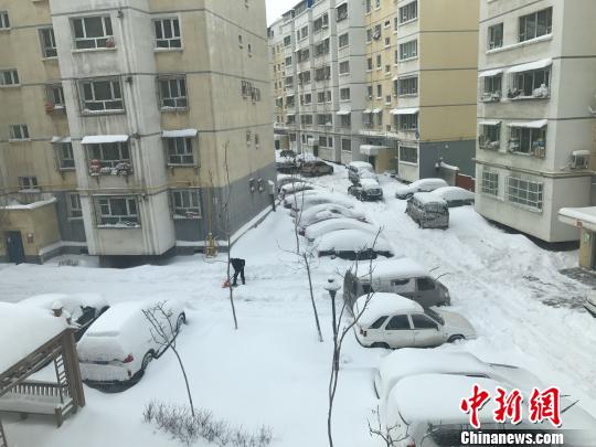 暴雪后民众在小区内清理积雪。　迪娜　摄