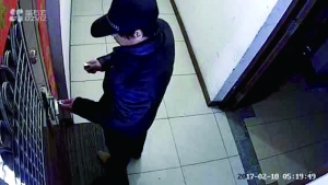 ③王女士家的监控画面显示，一名男子头戴帽子，捂着口罩，伪装“作案”。