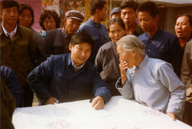  1983年，时任河北正定县委书记的习近平（前排居中），临时在大街上摆桌子听取老百姓意见。新华社发