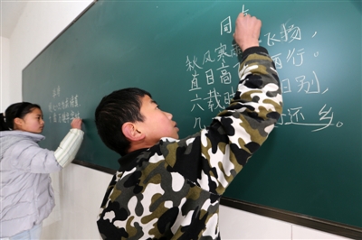 郑梦萍和杨超在老师面前展示自己写的诗