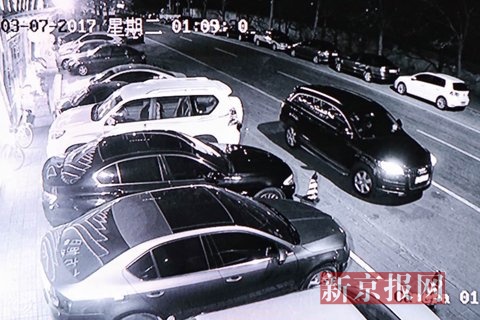 3月7日凌晨1点09分,东方旭日康浴城门口,一辆黑色奥迪车由北向南缓缓停下,画面中,车内司机正在抽烟。视频翻拍。新京报记者 李强 摄
